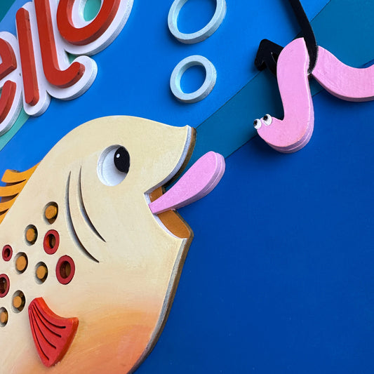 Colorful children's clock with a fish design on a blue background