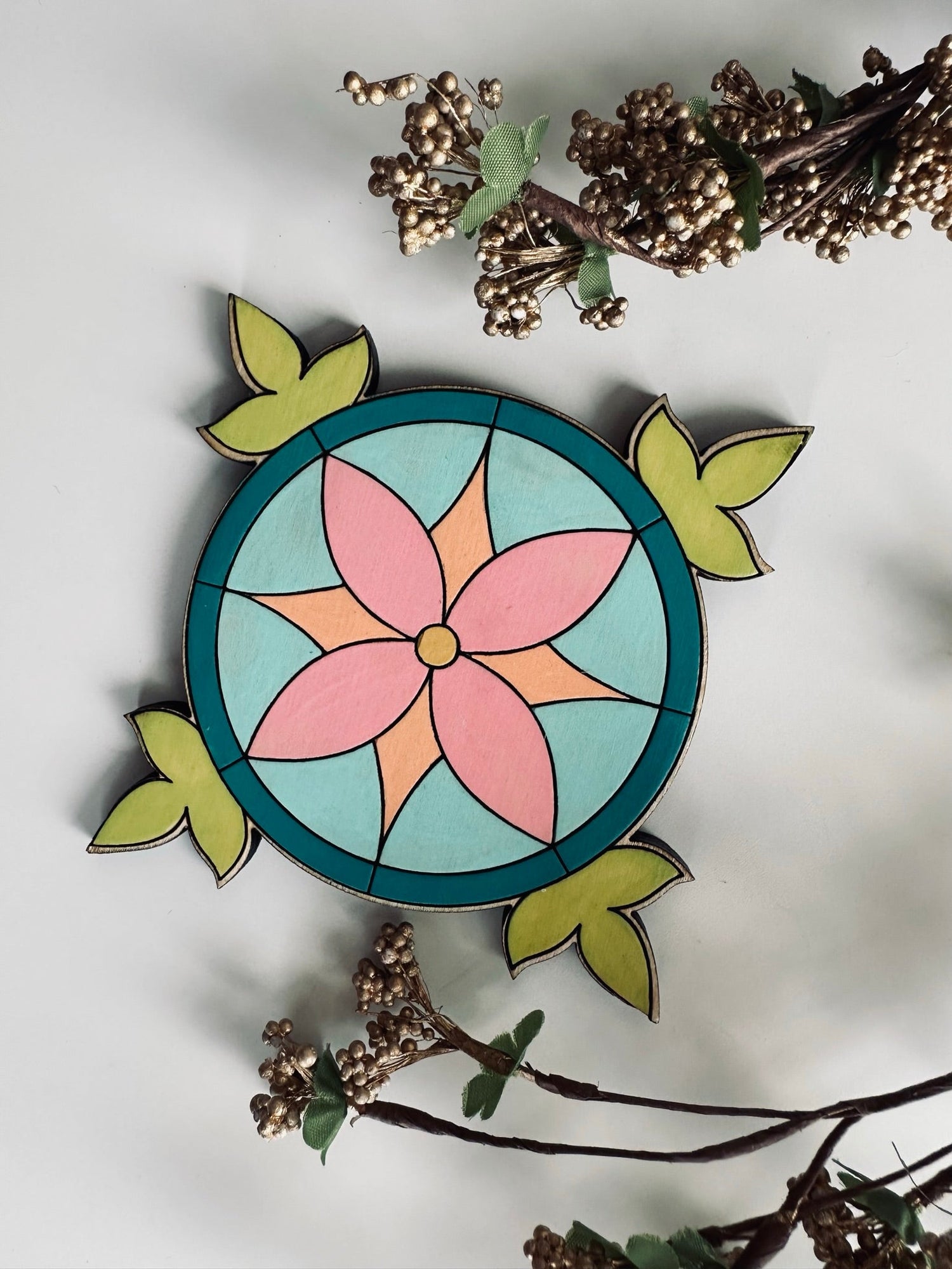 A laser cut coaster featuring a stained glass design.