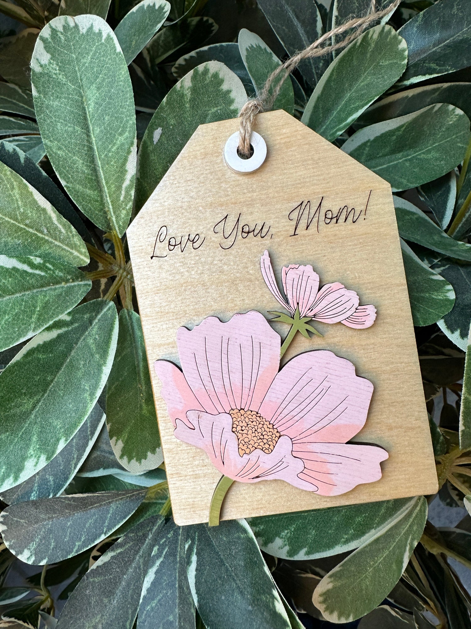 A laser cut gift tag with pink flowers and the words, Love You, Mom!