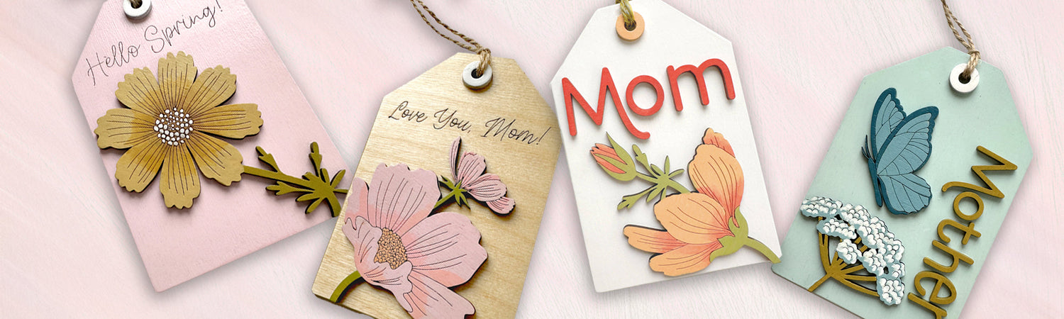 A laser cut gift tag with a flower, a butterfly and the word Mother on it.