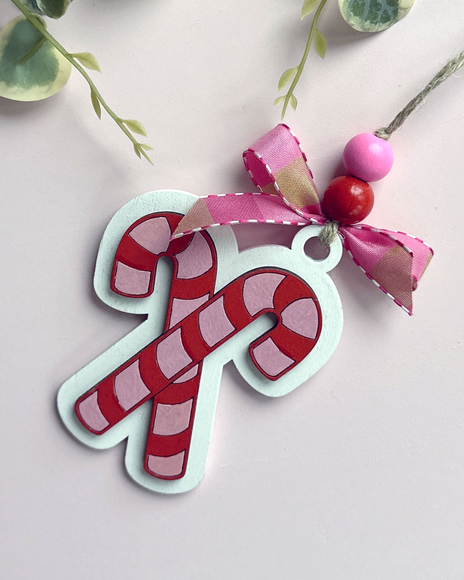 laser cut candy cane ornament in red and pink.
