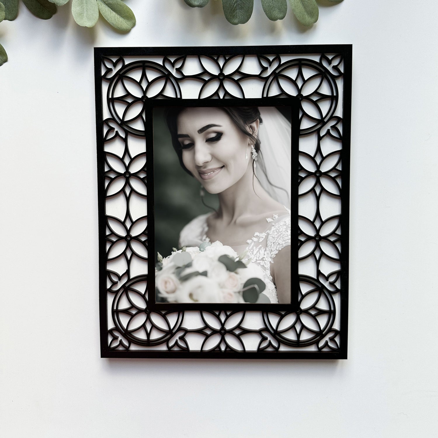 A laser cut frame with a stained glass design showing a bridal photo.