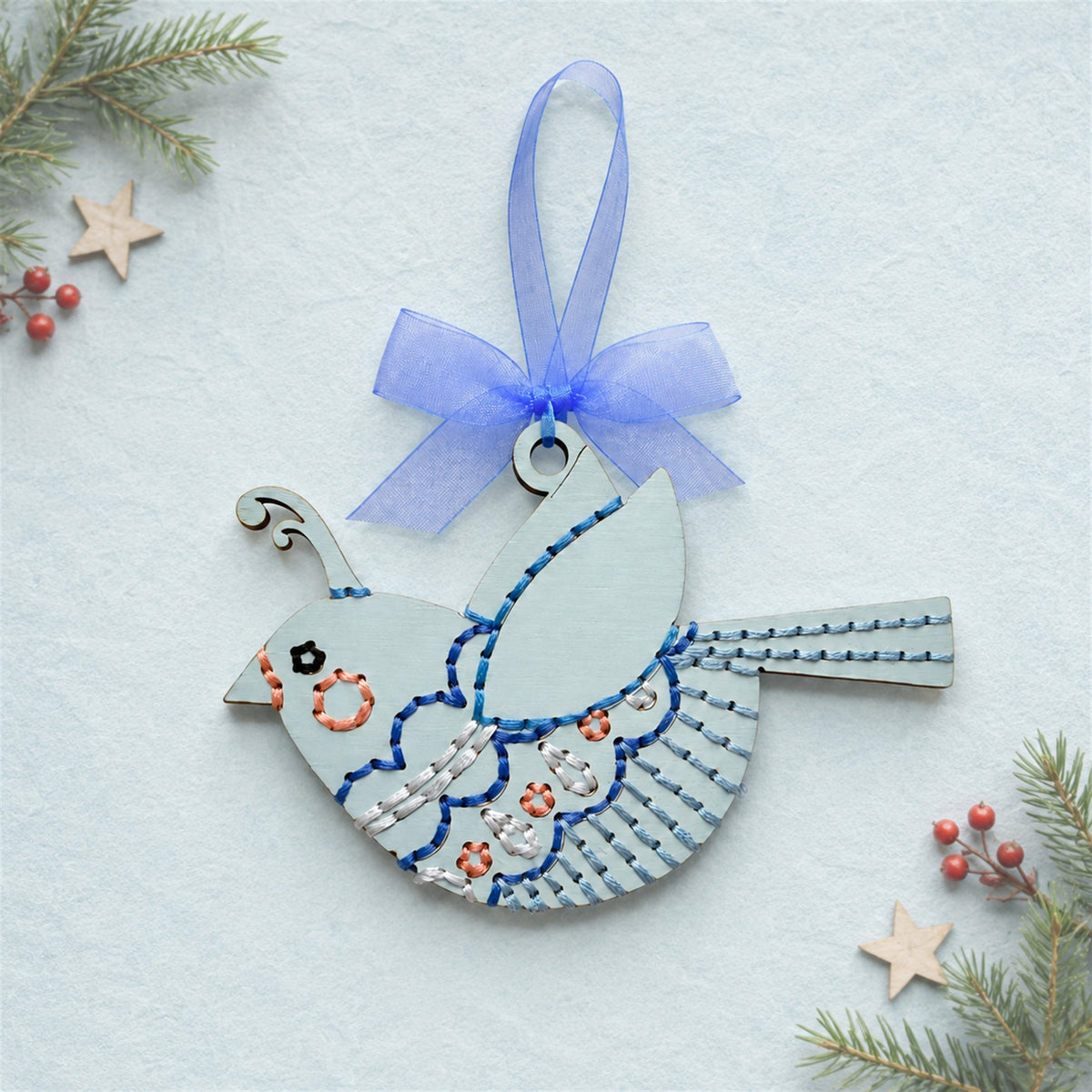 Whimsical songbird embroidery ornament, pale blue painted wood bird with blue stitching and a blue ribbon