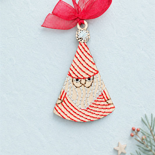 Folk art Santa embroidery ornament, light wood triangle Santa with red striped stitching and a red ribbon
