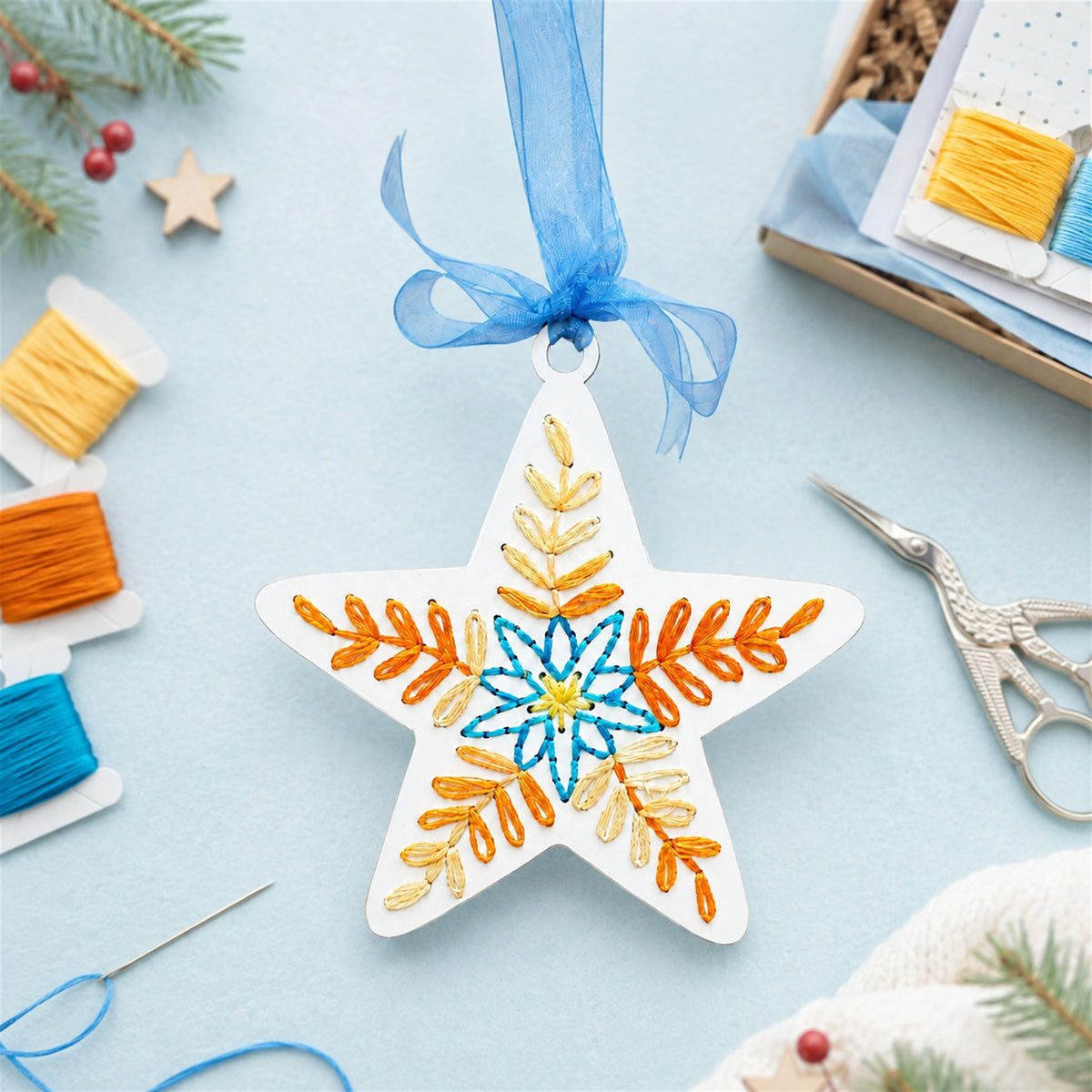 Folk art star ornament with embroidery floss, needle and scissors, showing the DIY embroidery kit