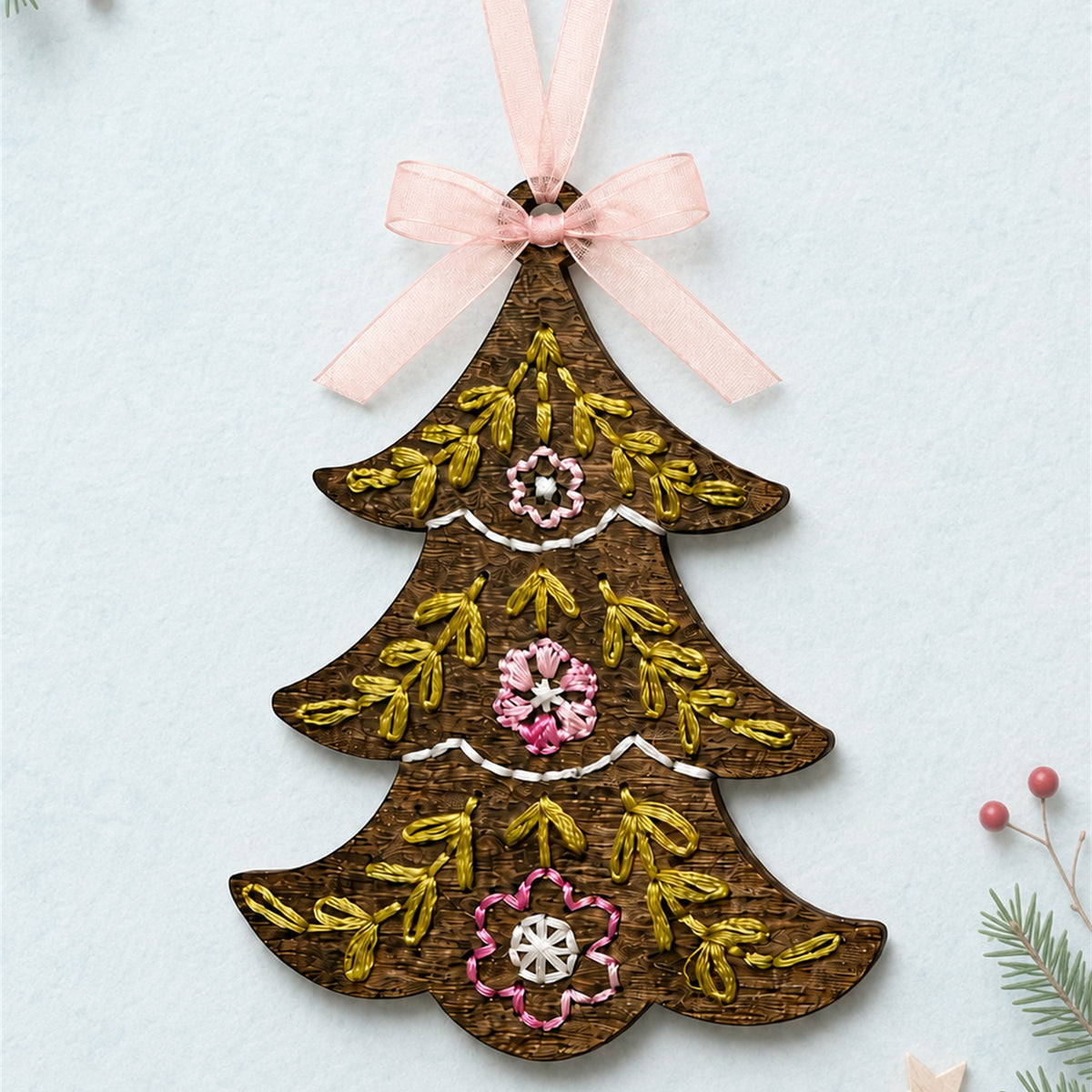 Folk art Christmas tree embroidery ornament, brown stained wood tree with gold and green stitching and a pink ribbon