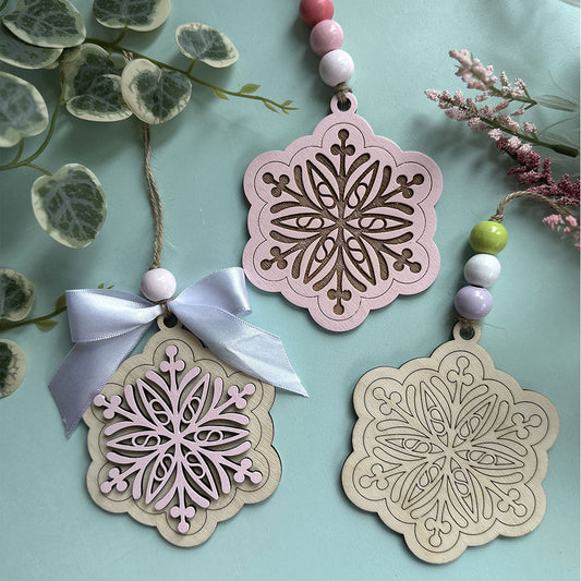 Decorative snowflake ornaments with ribbons and beads on a light blue background