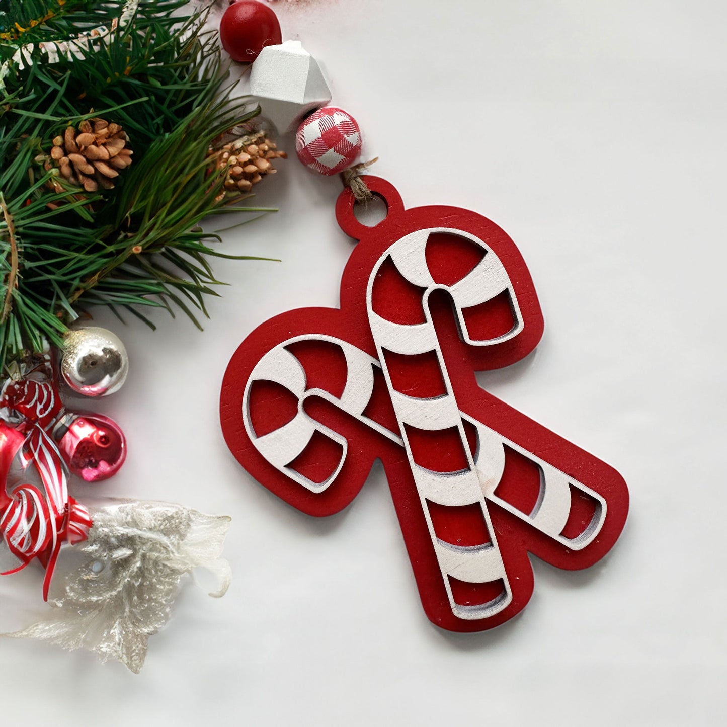 Candy cane ornament with Christmas decorations on a white background.