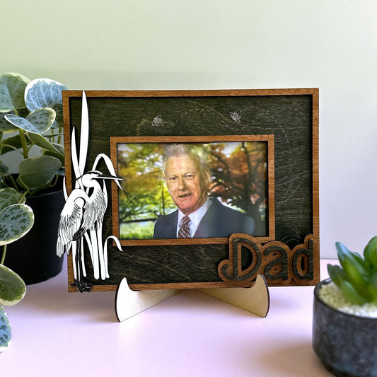Small framed picture of a man on a stand with decorative elements on a light surface.