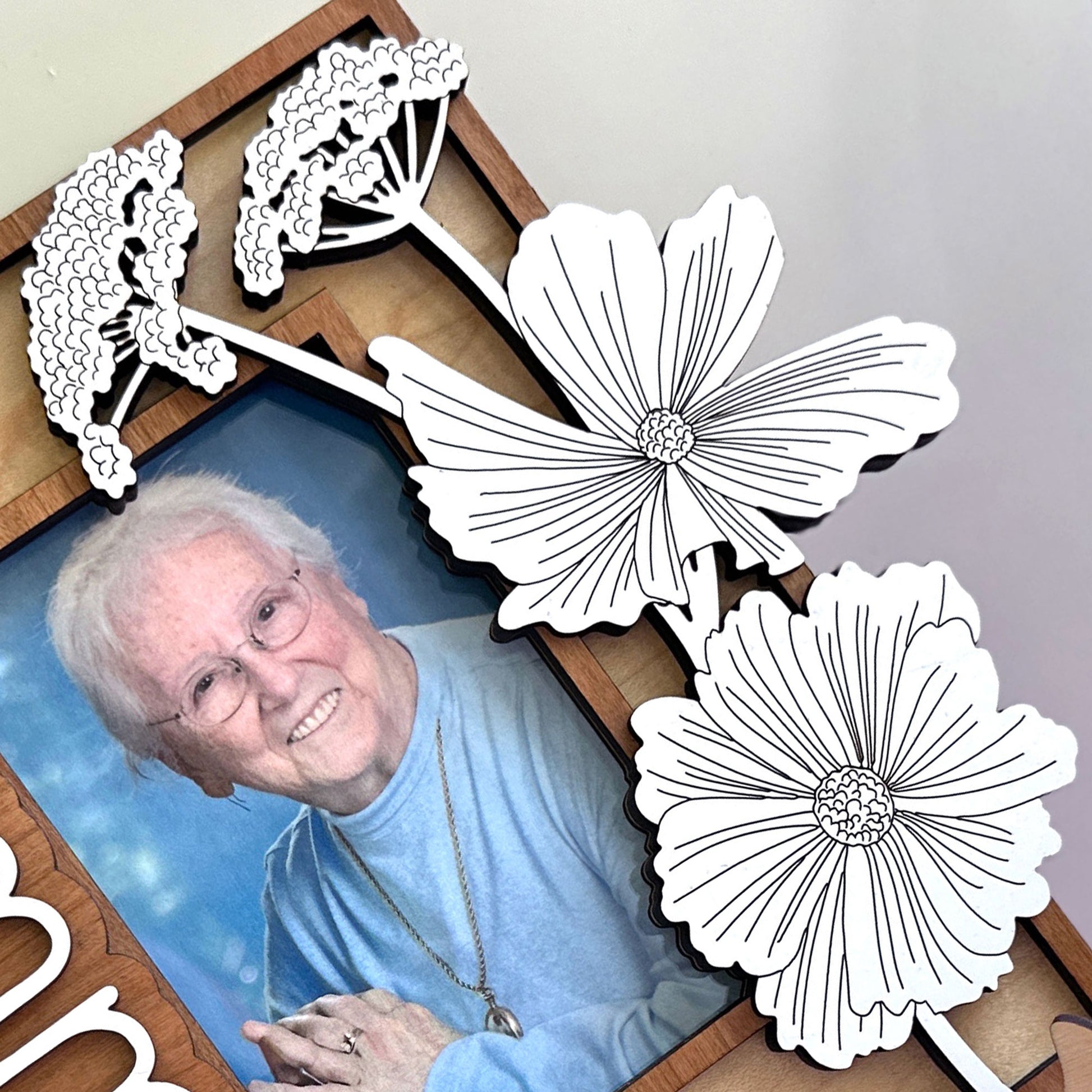 Smiling older woman with a decorative flower frame