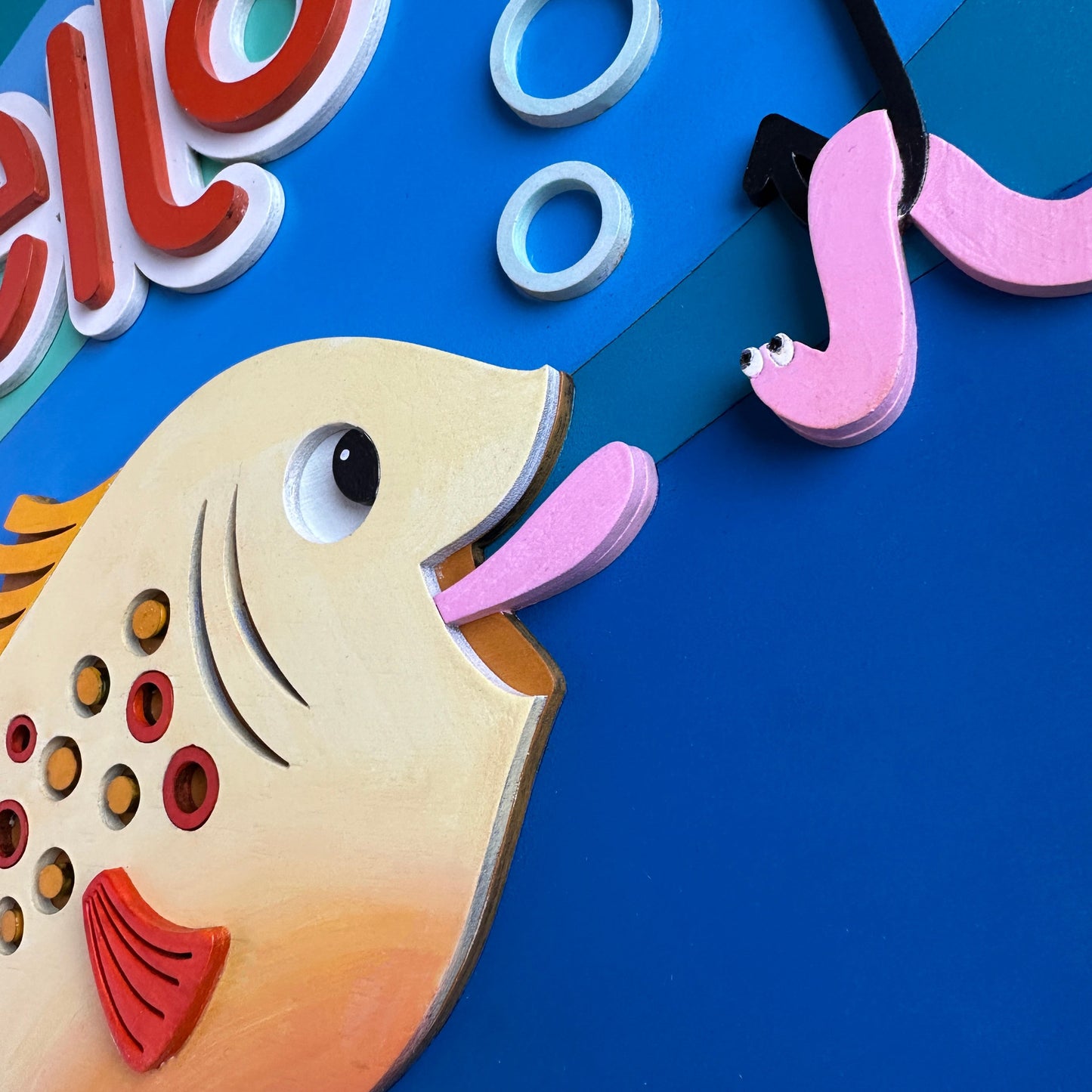 Colorful children's clock with a fish design on a blue background
