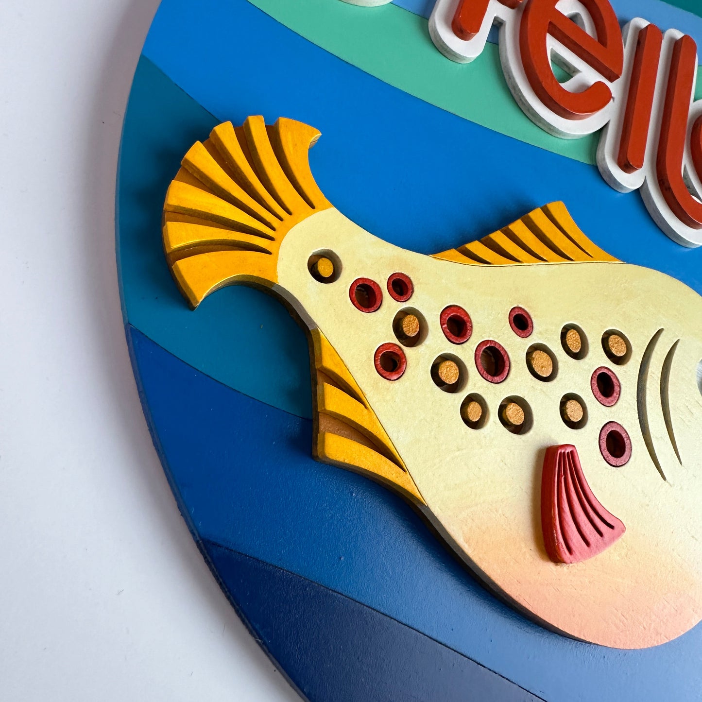 Colorful fish-shaped object with 'Hello' text on a blue background