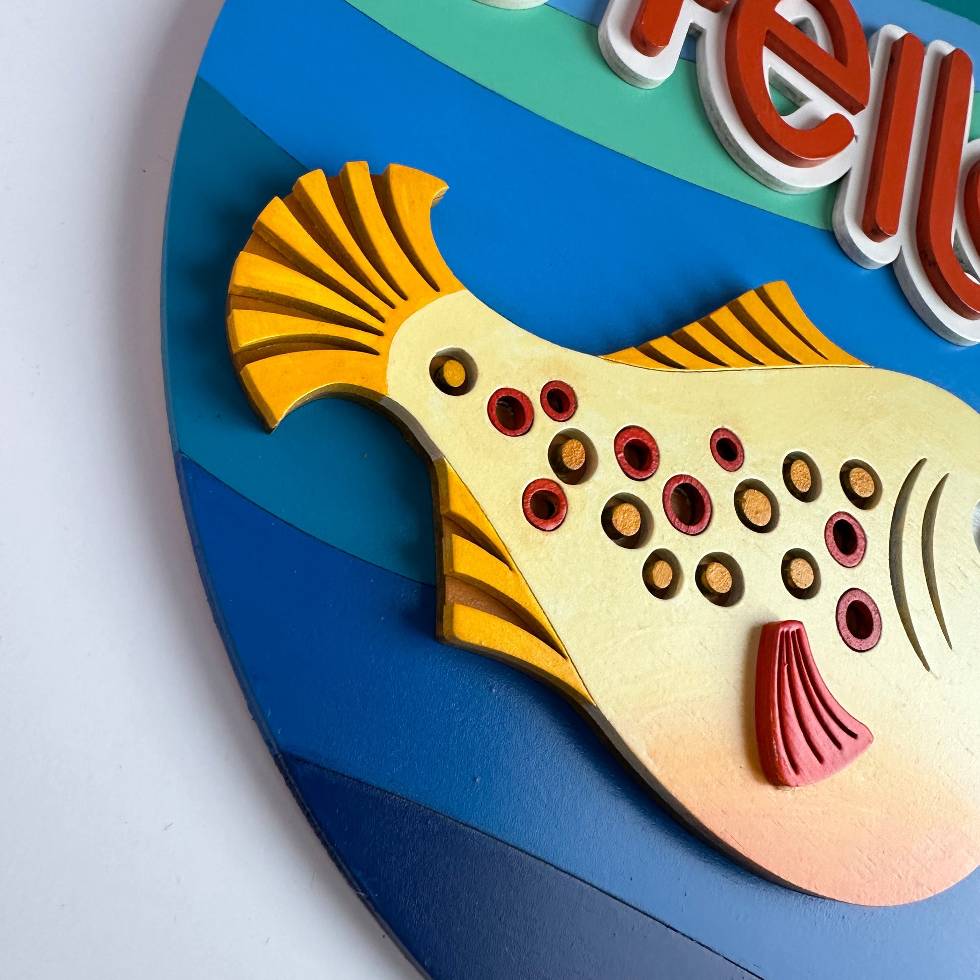 Colorful fish-shaped object with 'Hello' text on a blue background
