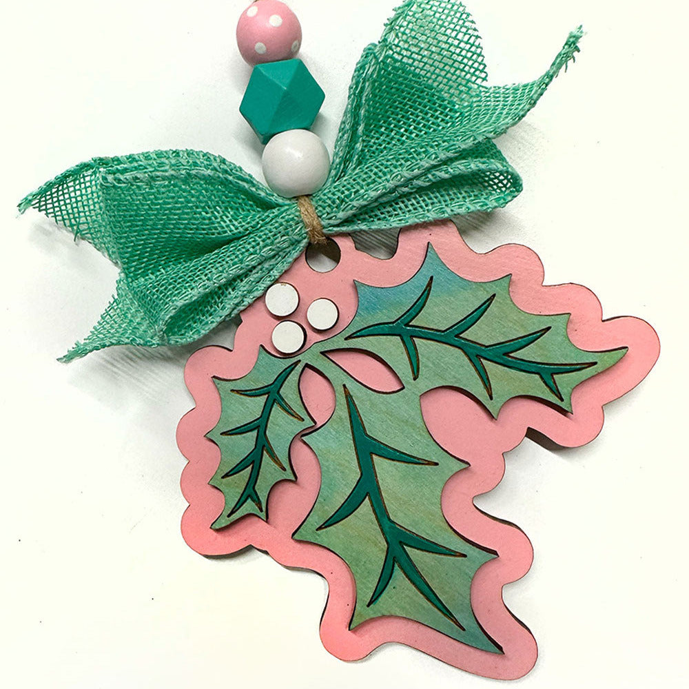 Decorative holly leaf ornament with green leaves and pink outline on a white background