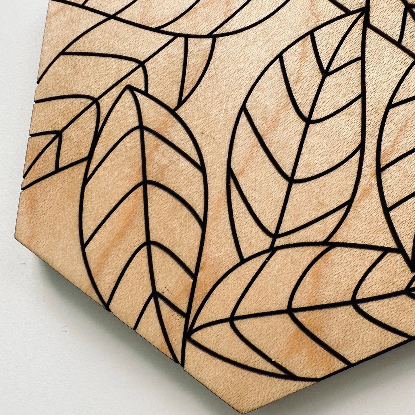 Hexagonal tile with leaf pattern on a beige background