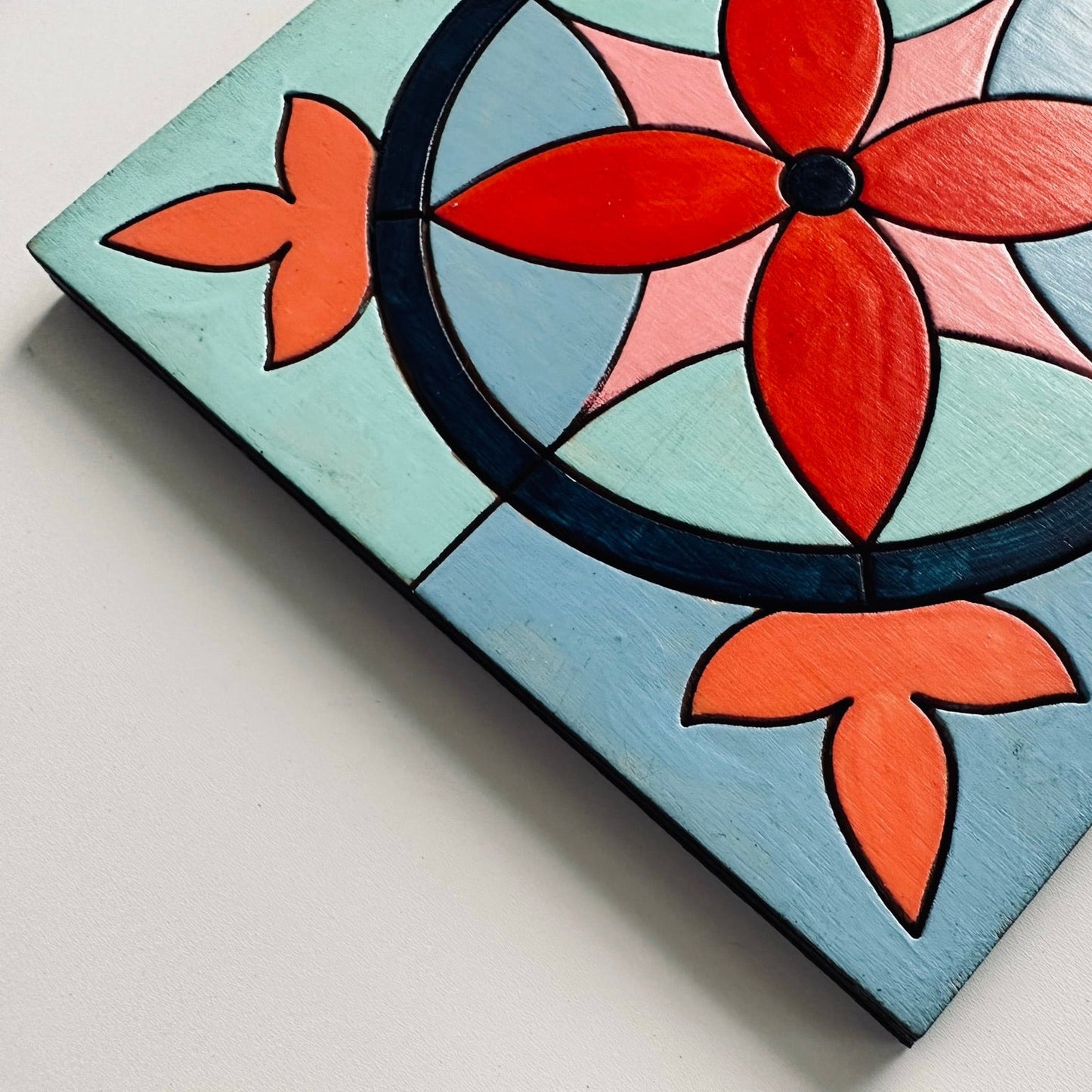 Decorative coaster with floral design on a light blue background