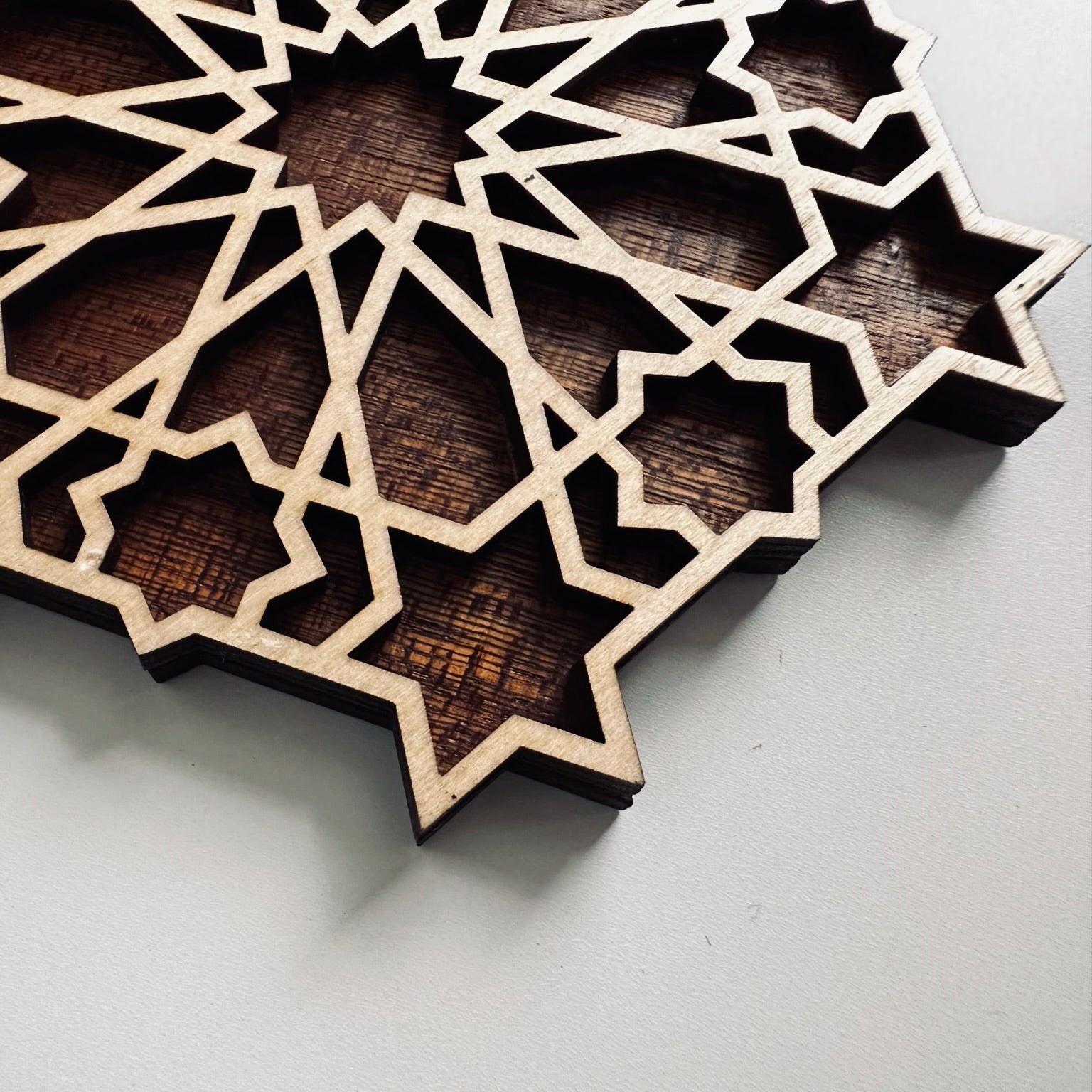 Wooden geometric star coaster on a white background