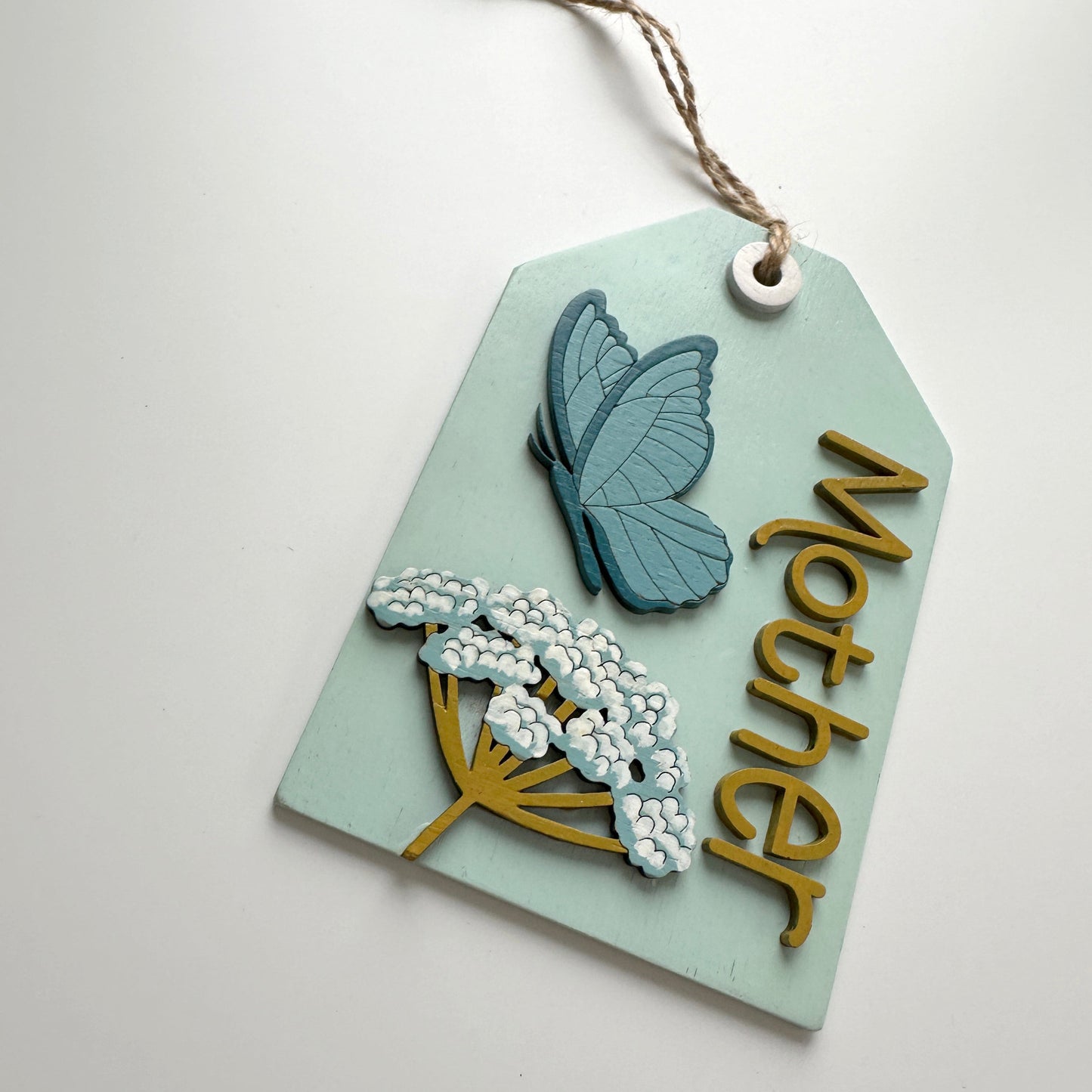 Decorative tag with butterfly and flowers design on a light blue background
