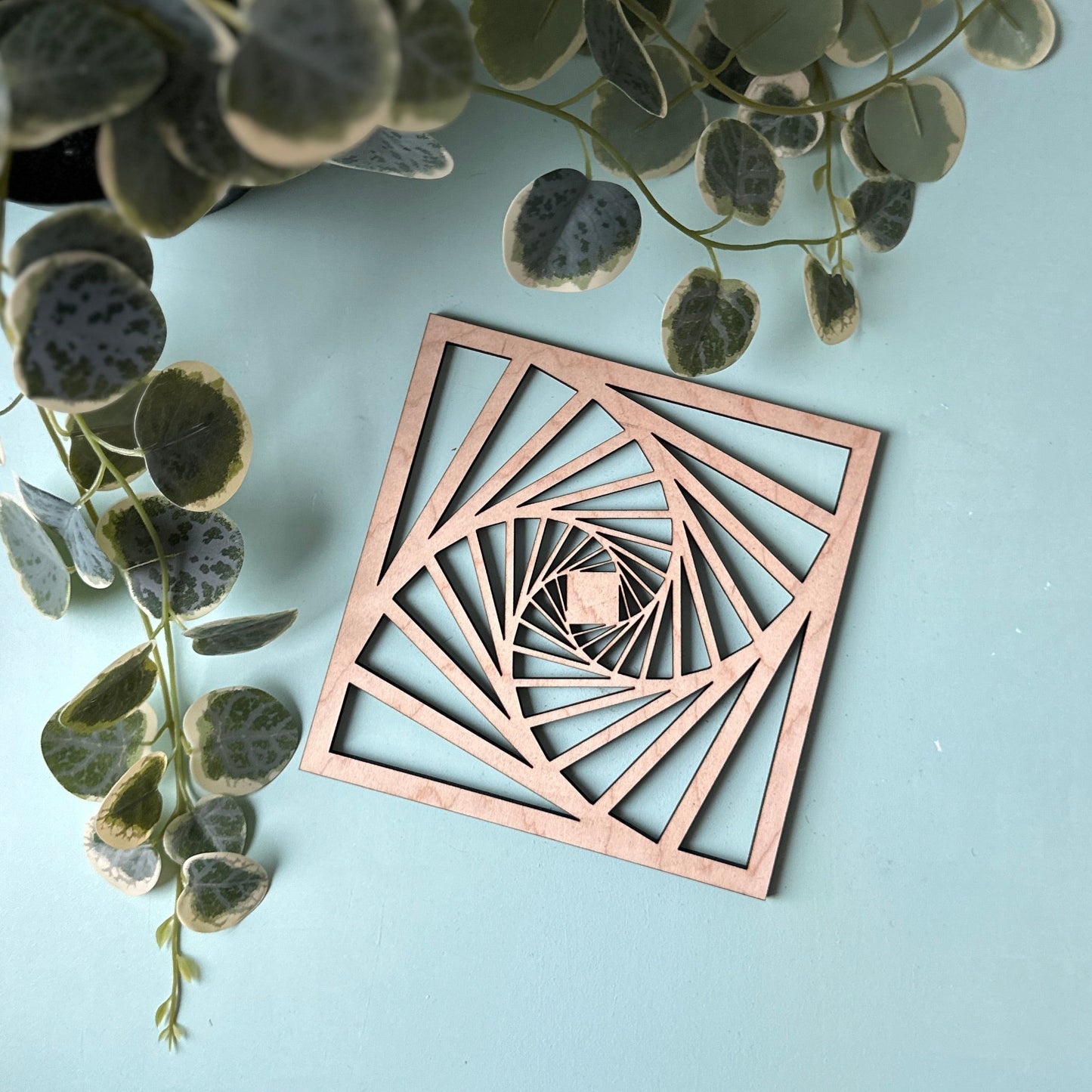 A laser-cut trivet with a decorative design on a light background