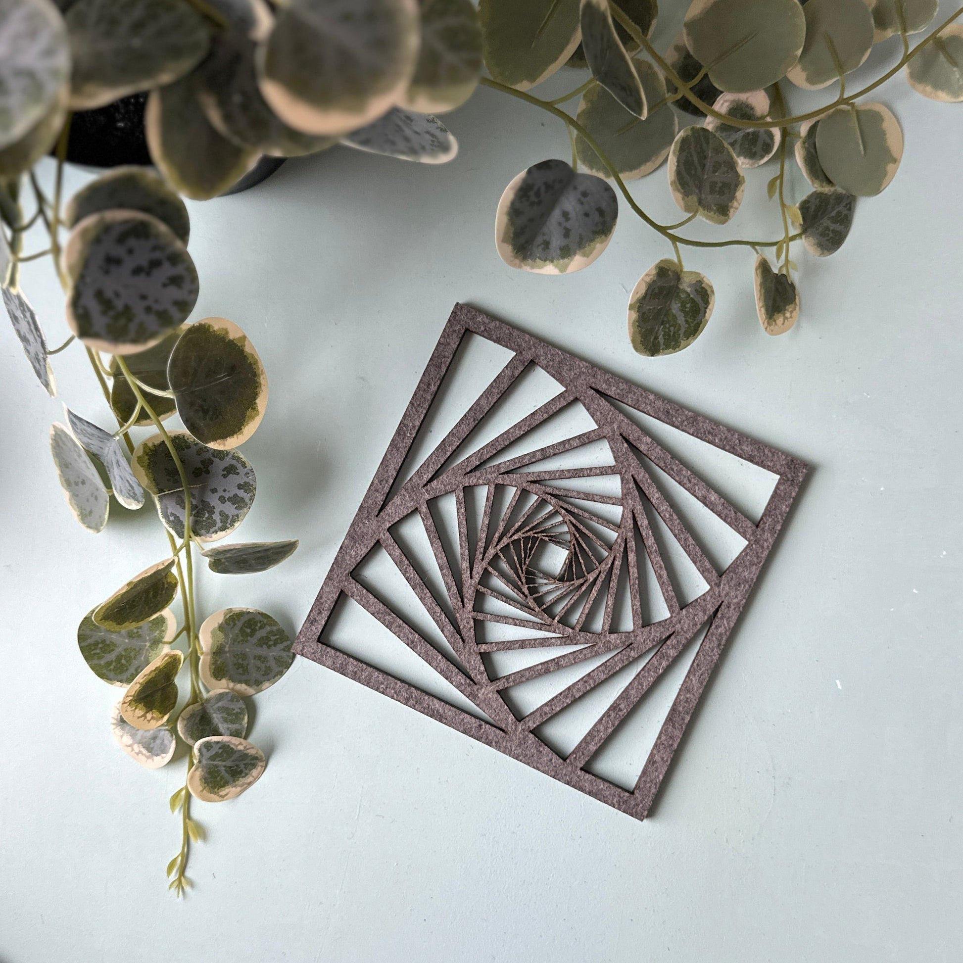 A laser-cut trivet with a decorative design on a light background