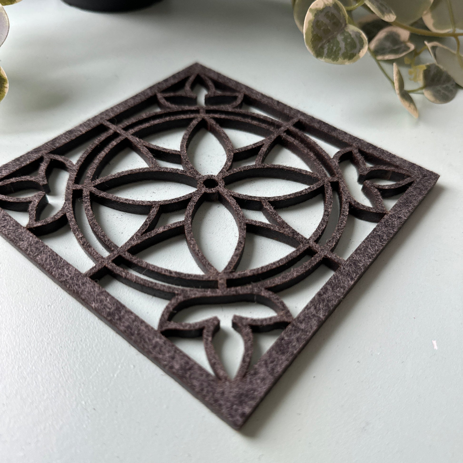 A felt laser-cut trivet with a stained glass design