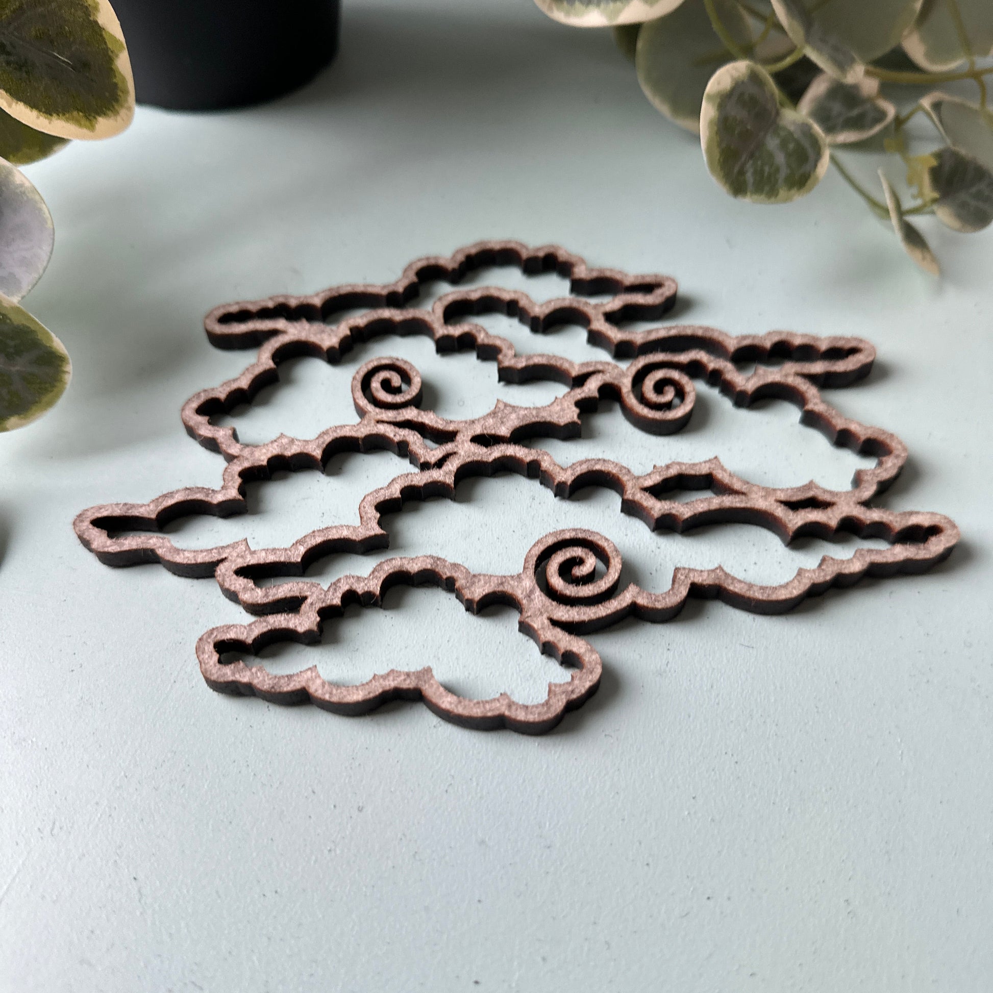 Decorative trivet with intricate designs on a light gray background