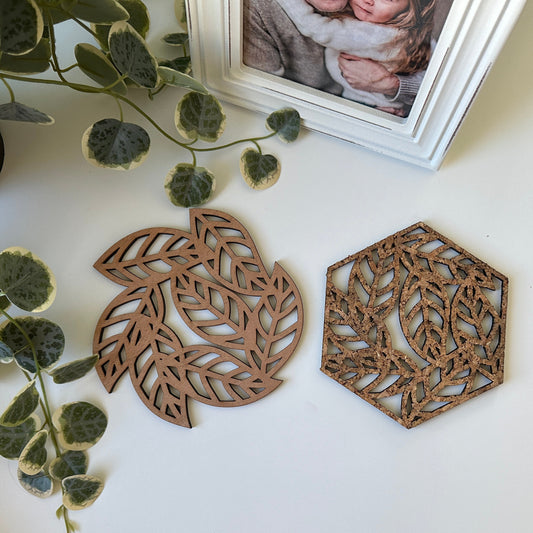 Two  decorative trivets with a leave design and a photo frame in the background
