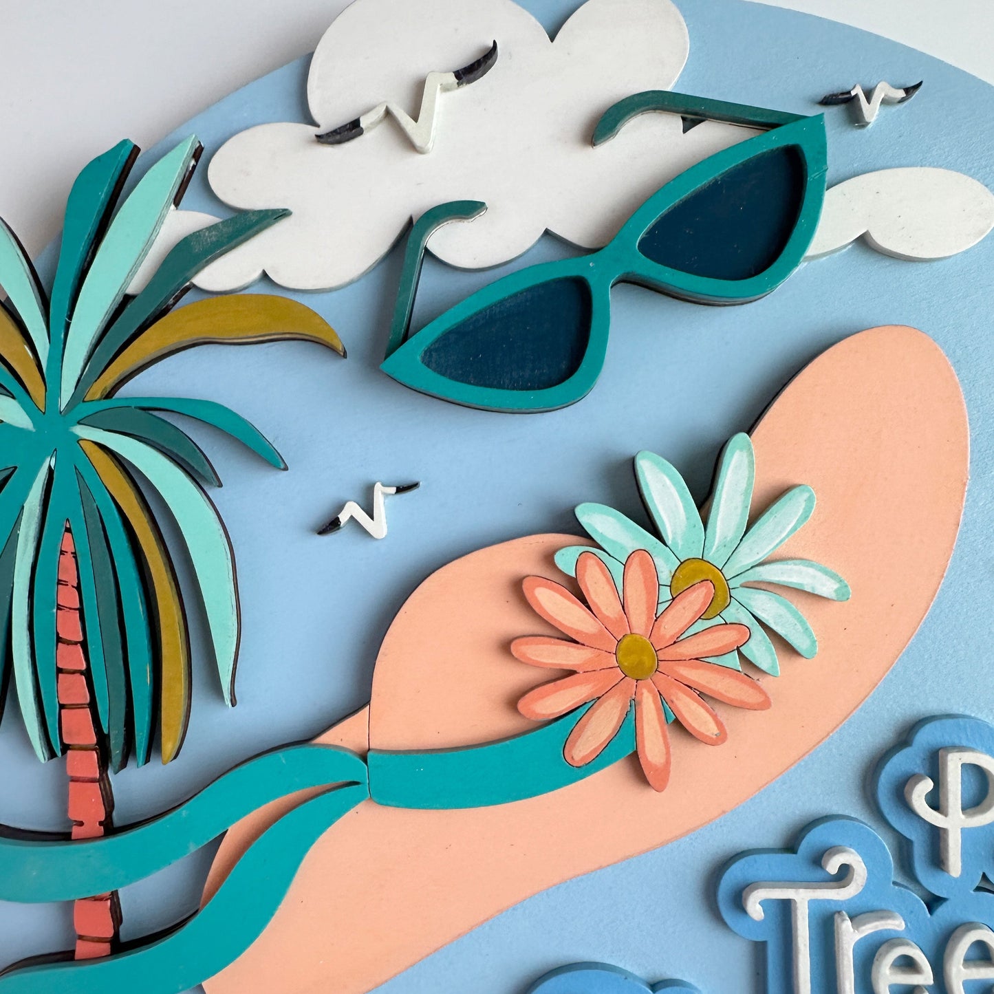 Decorative wall art with sunglasses, palm tree, flowers, and 'Pineapple Ocean' text on a light blue background.