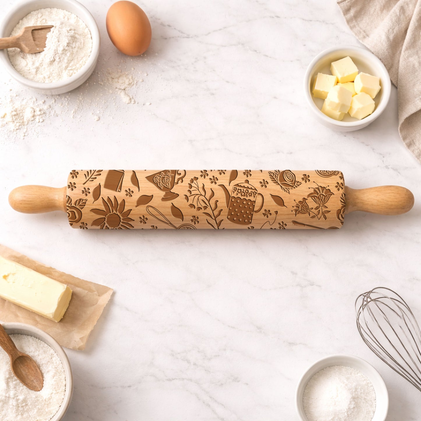 Decorative rolling pin with embossed designs on a kitchen counter with baking ingredients.