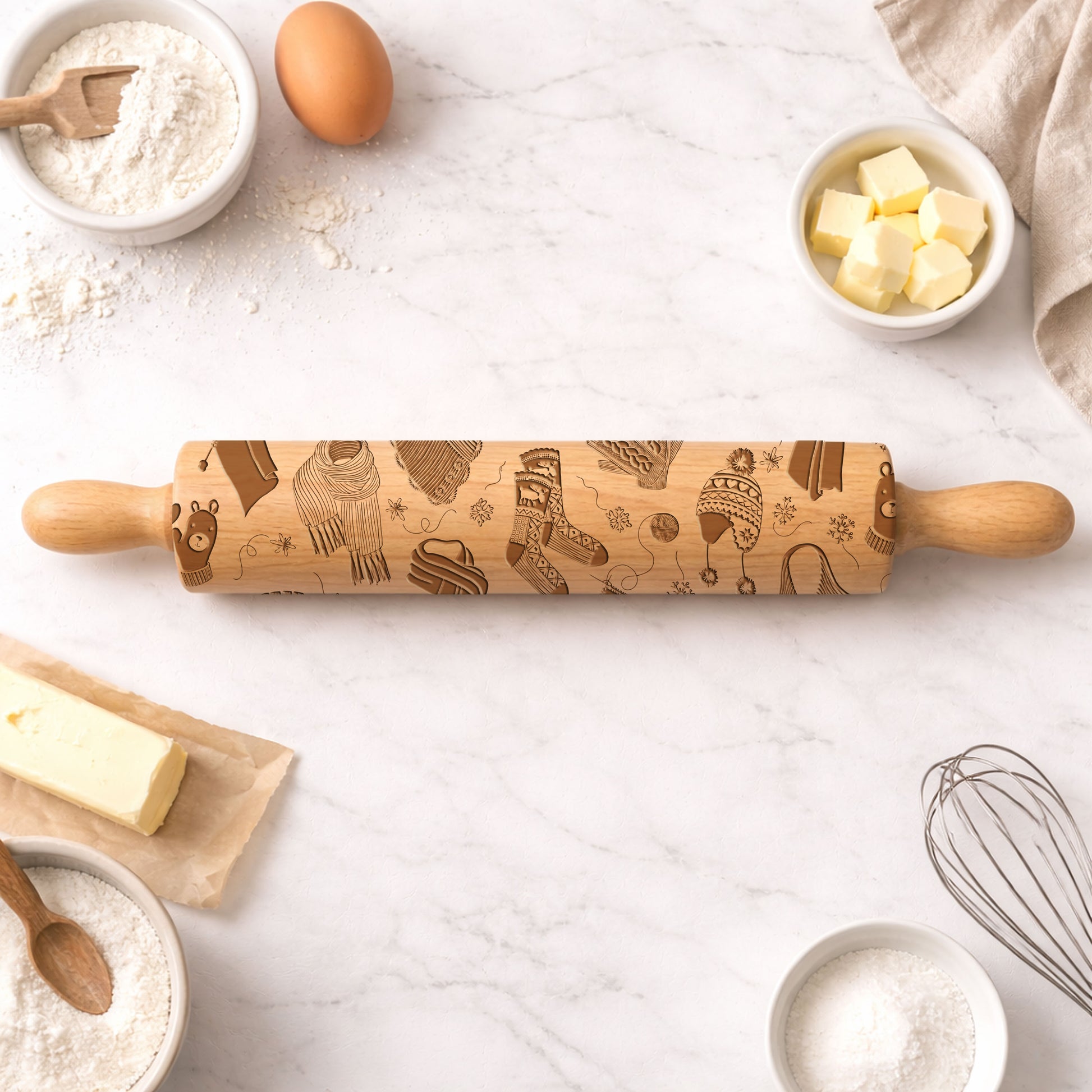 Decorative rolling pin with embossed designs on a kitchen counter with baking ingredients.