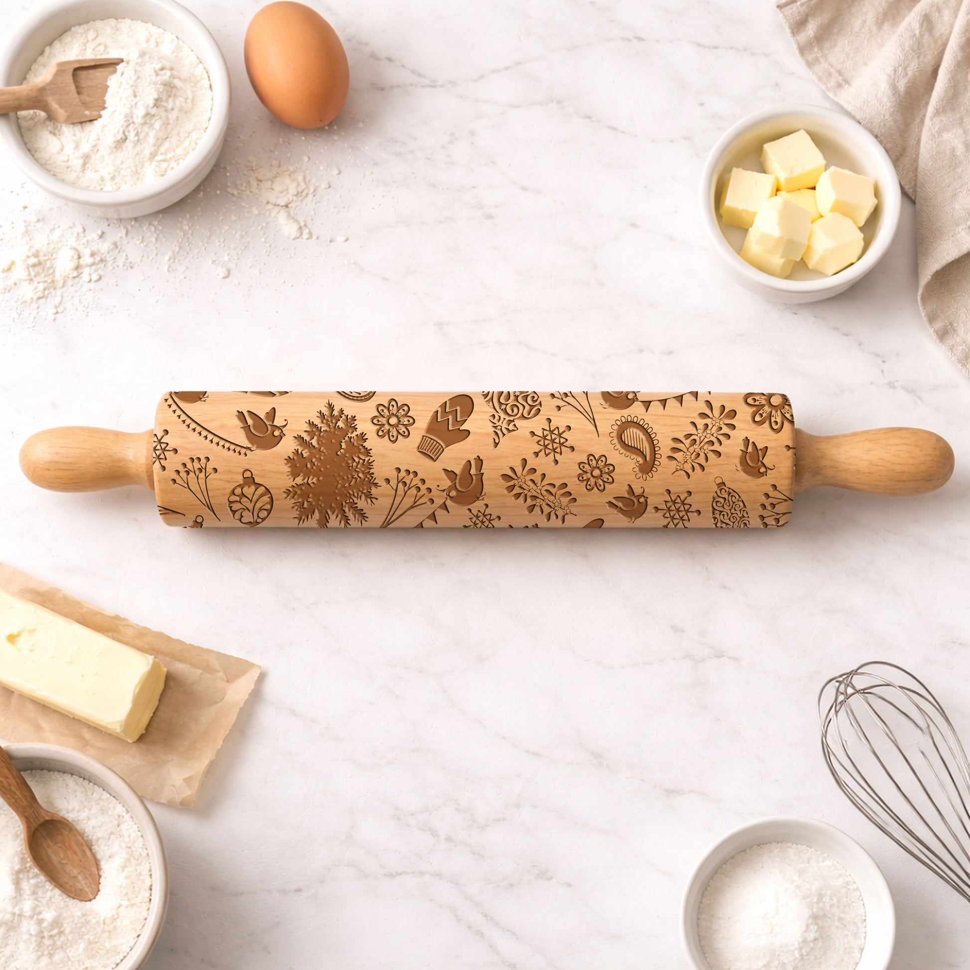 Wooden rolling pin with embossed designs on a kitchen counter with baking ingredients.