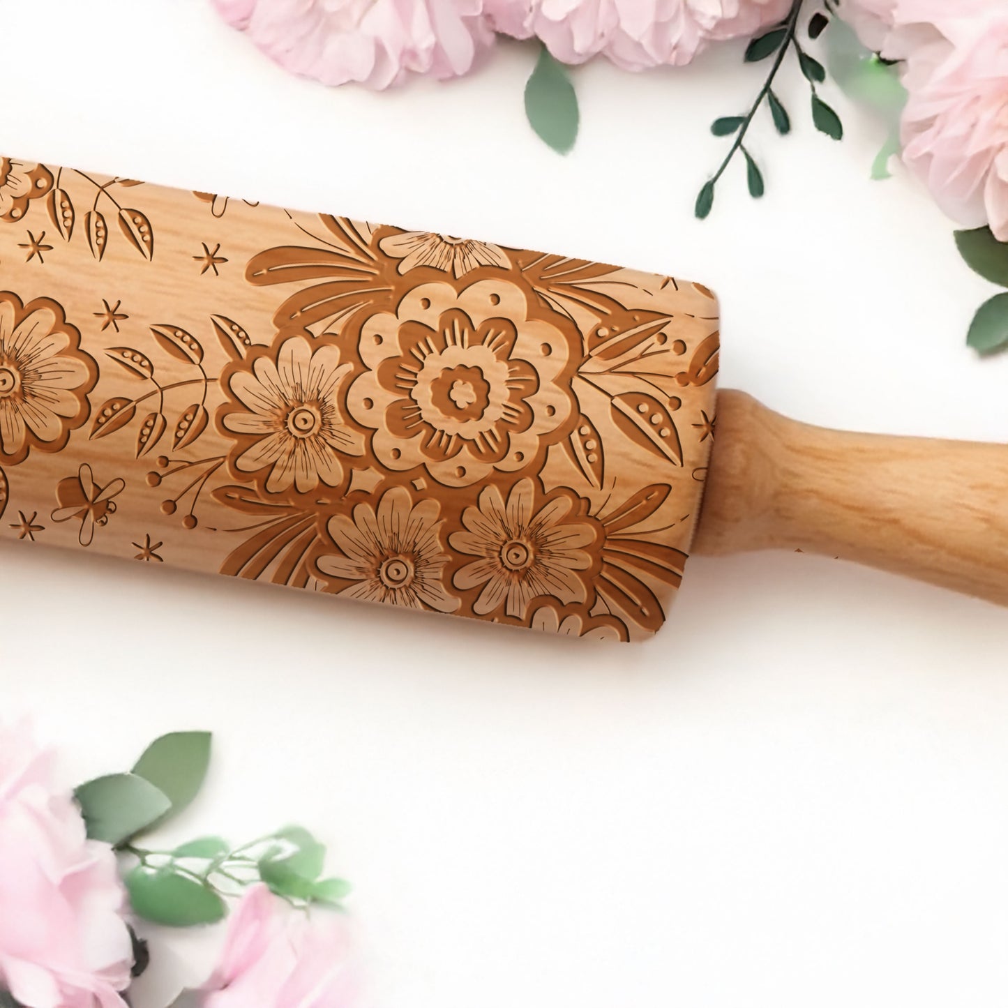 Decorative rolling pin with floral patterns on a white background.
