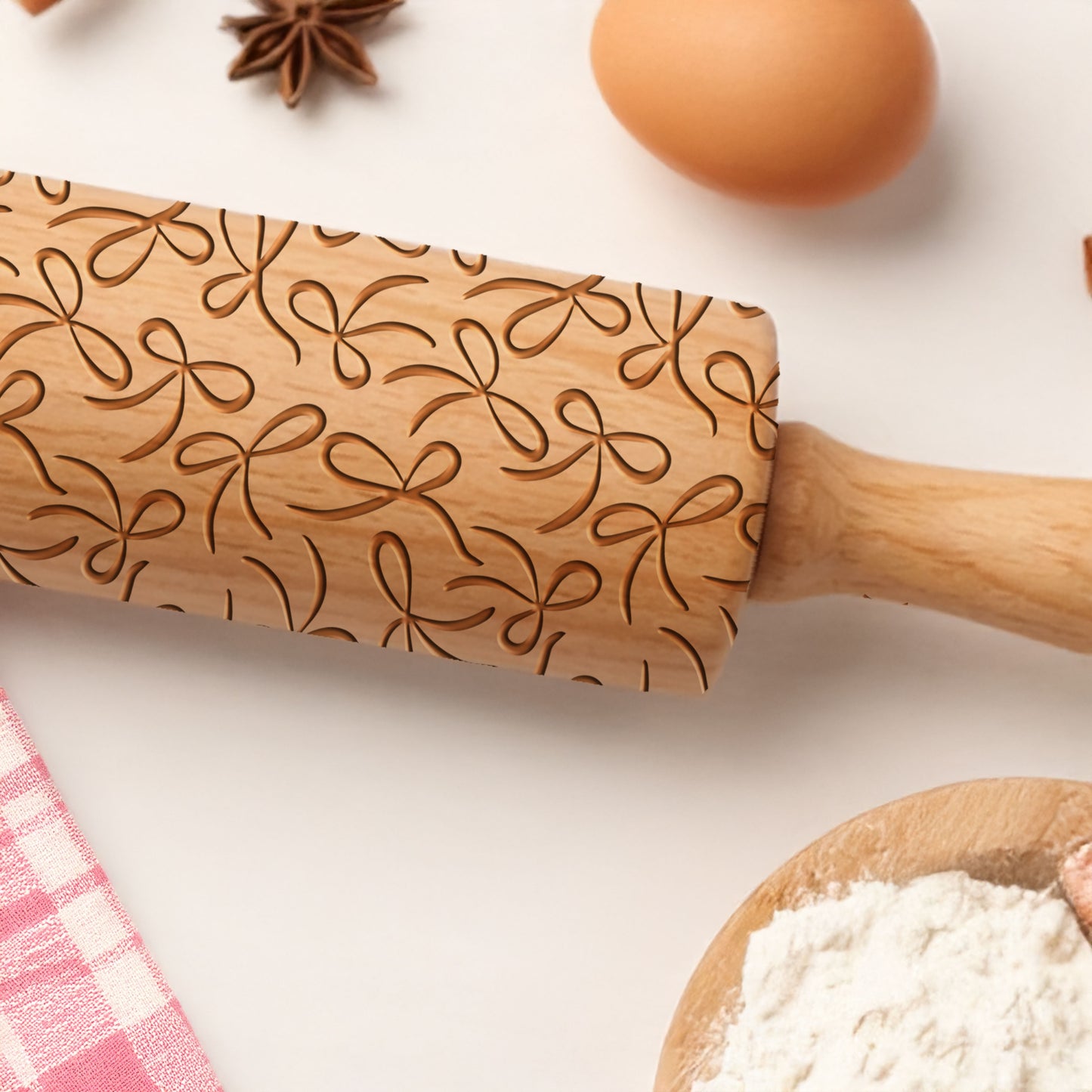 Wooden rolling pin with decorative patterns on a kitchen counter with flour and eggs.
