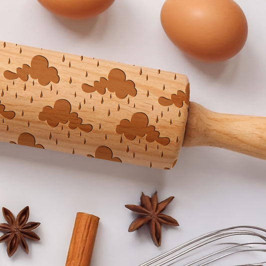 Wooden rolling pin with star anise, cinnamon stick, and whisk on a white background