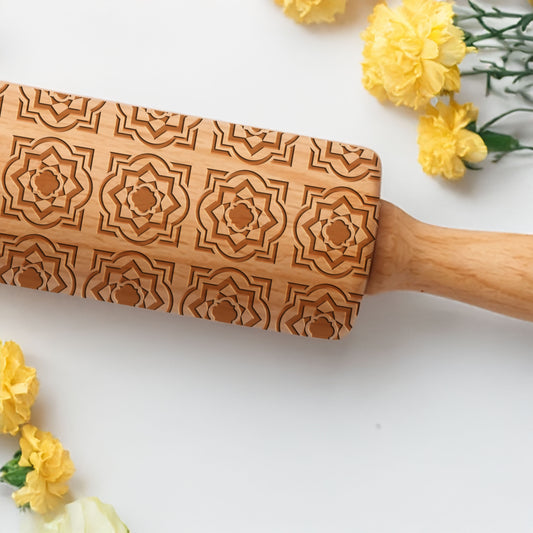 Wooden rolling pin with decorative patterns on a white background with yellow flowers.