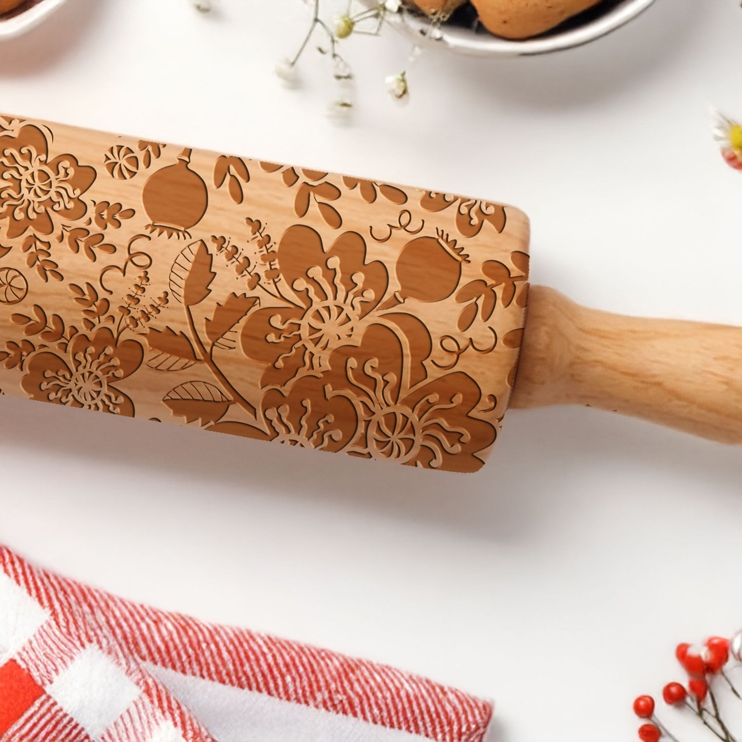 Wooden rolling pin with floral patterns on a white surface