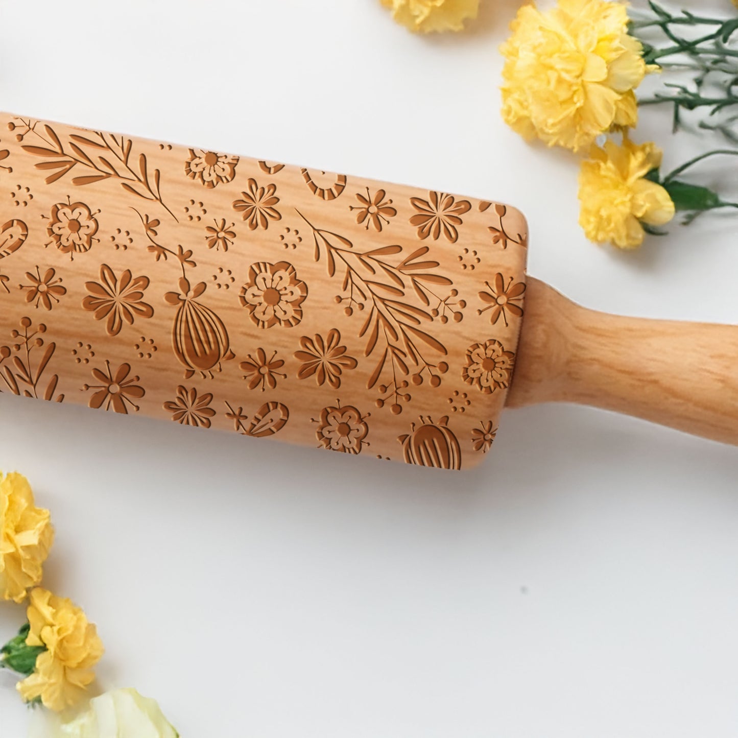 Wooden rolling pin with floral patterns on a white background with yellow flowers.