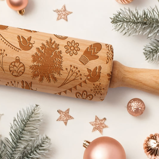 Wooden rolling pin with Christmas patterns on a white surface with festive decorations.