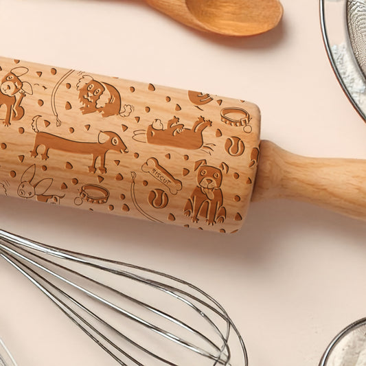 Wooden rolling pin with engraved designs on a kitchen counter with utensils.