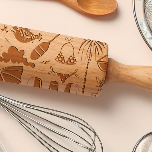 Wooden rolling pin with engraved designs on a kitchen counter with utensils.
