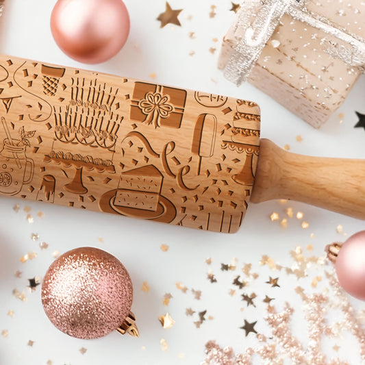 Wooden embossing rolling pin with festive designs on a white surface with Christmas decorations.