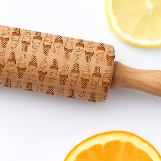 Wooden rolling pin with ice cream cone pattern on a white background with sliced oranges and lemons.