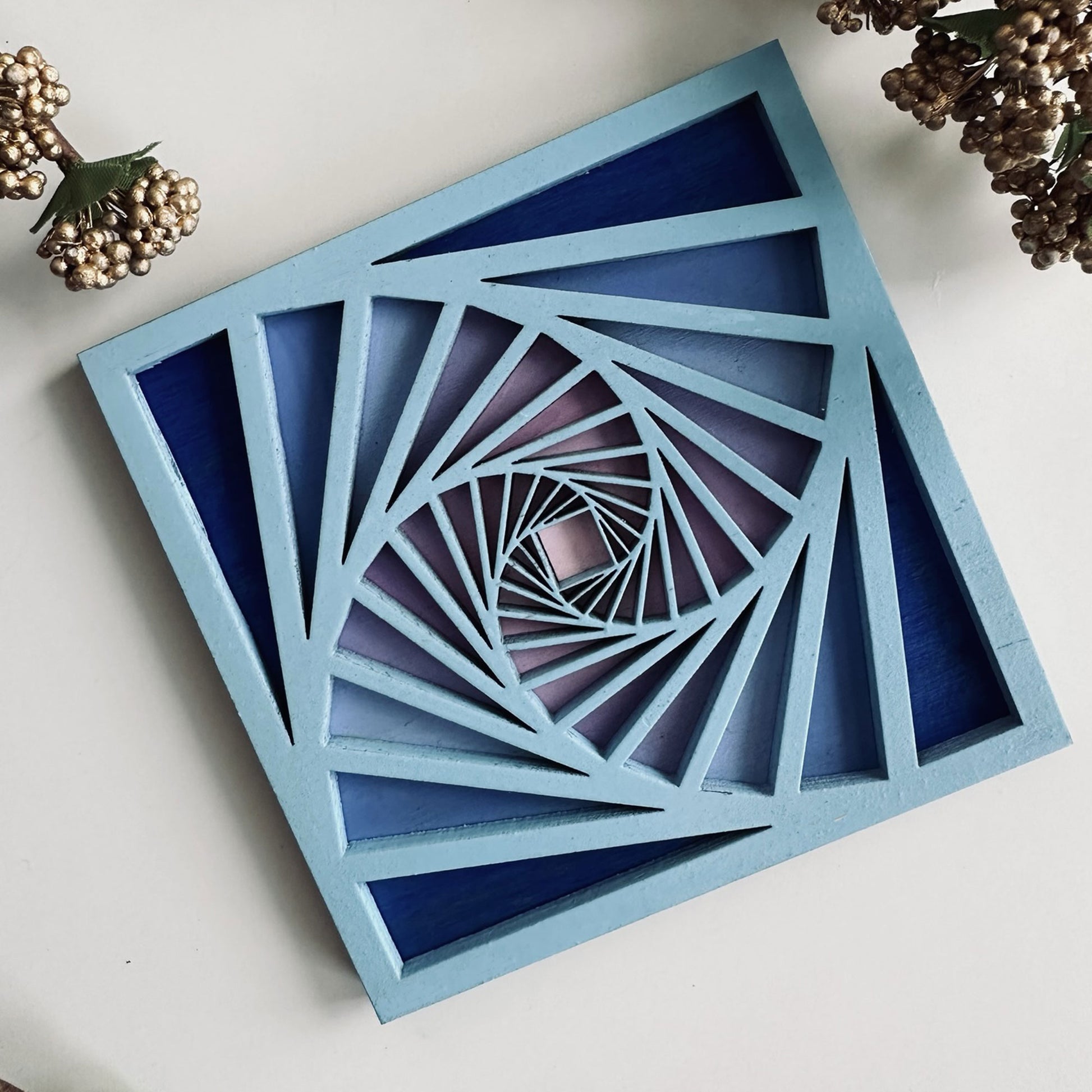 Geometric blue and purple coaster on a white surface with decorative elements.