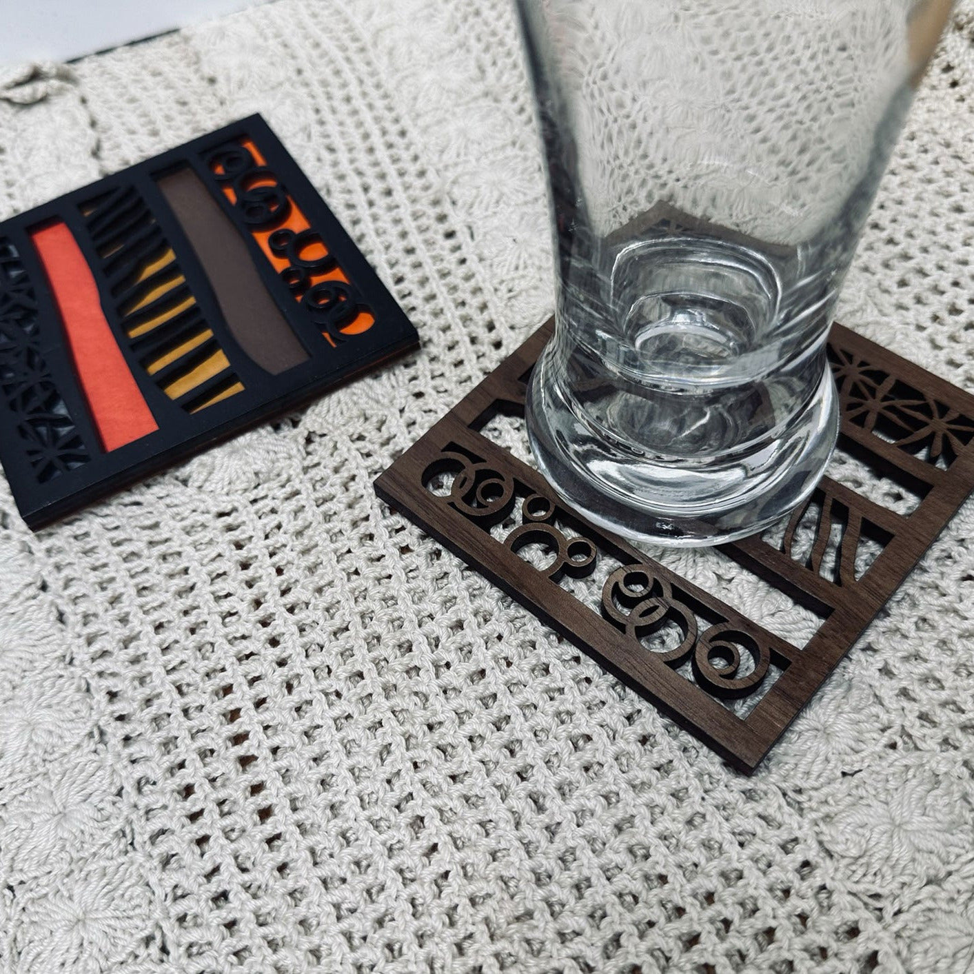 Decorative wood trivet with a glass on a textured surface