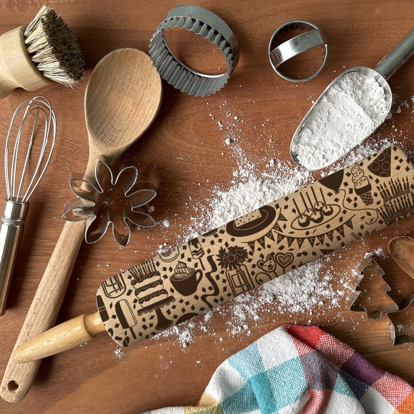 Wooden rolling pin with embossed designs on a wooden surface with baking tools and flour.