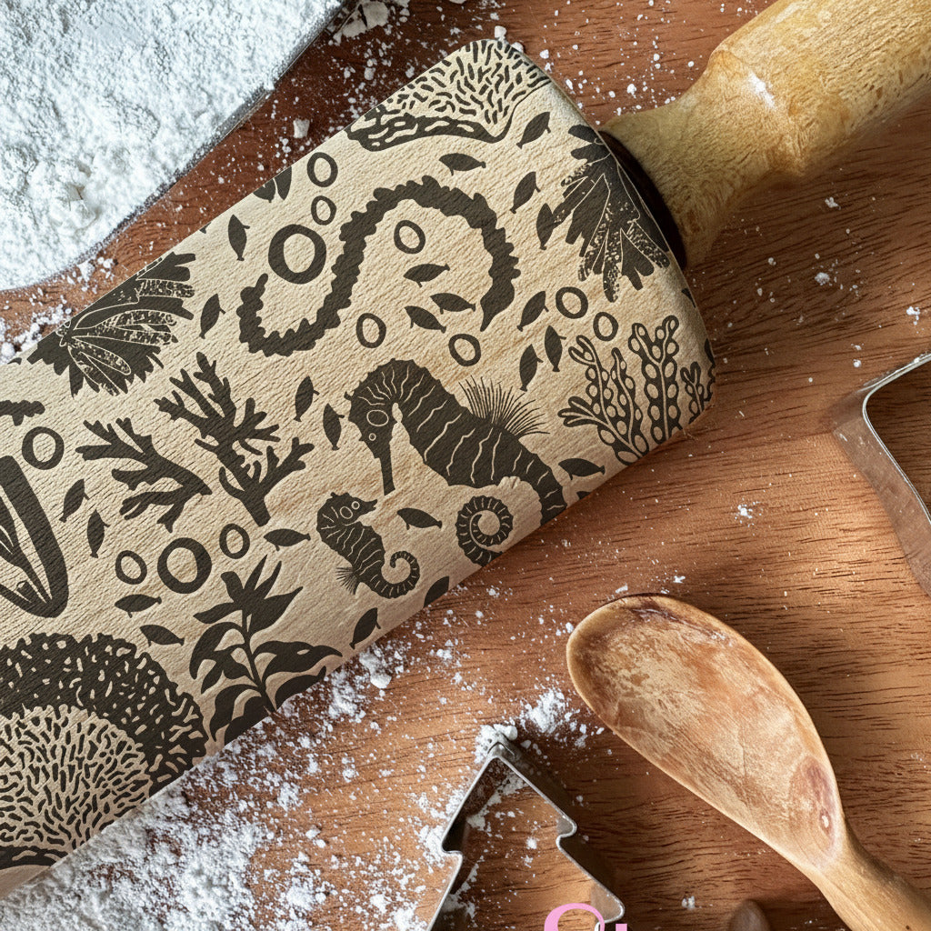Wooden rolling pin with sea-themed patterns on a wooden surface with flour, branded 'PickleandBeachStudio'.