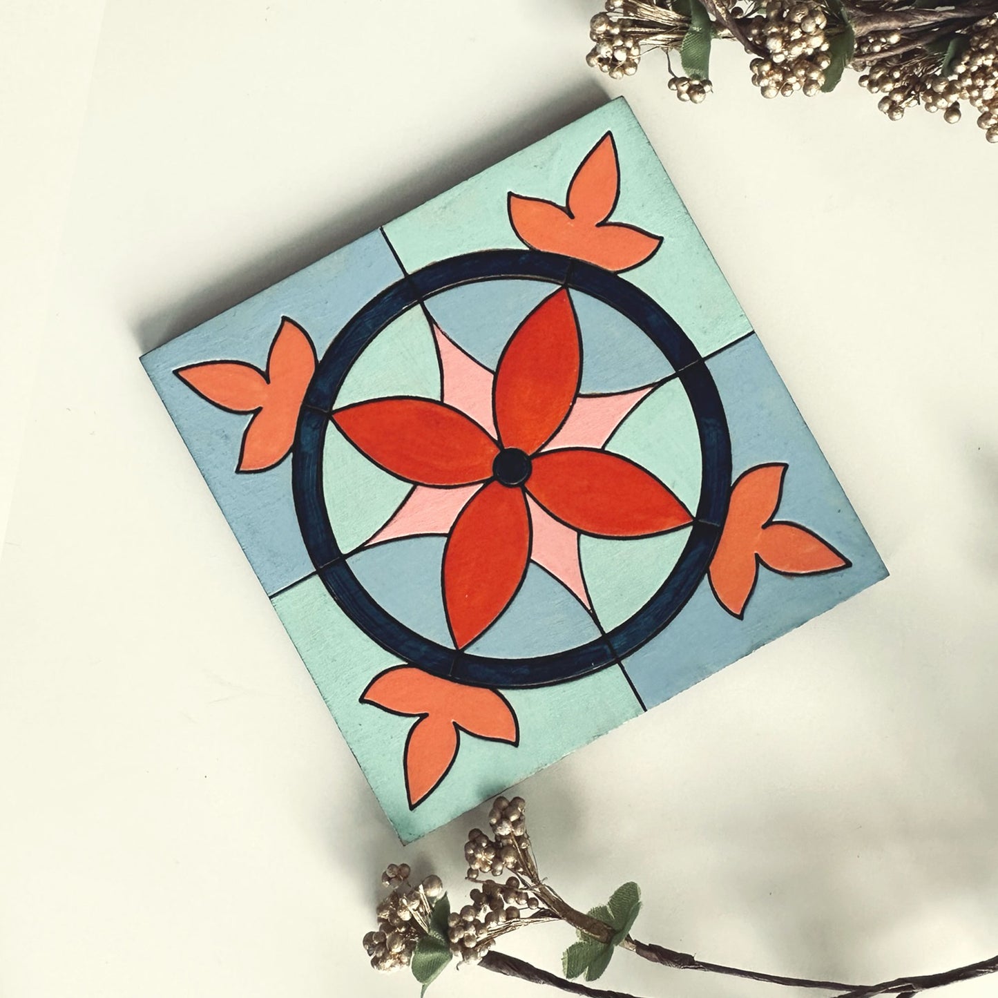 Decorative coaster with a floral design on a light blue background
