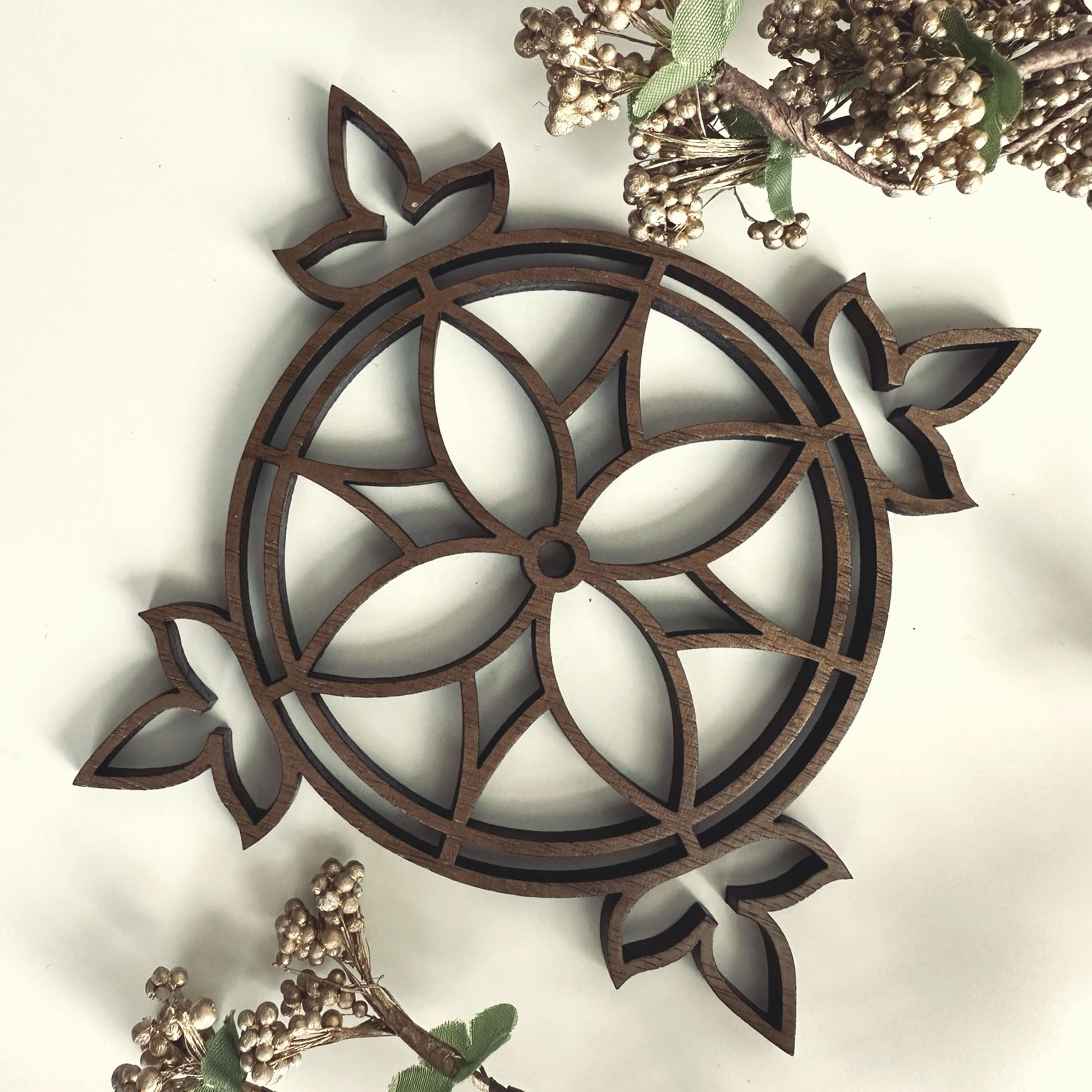 Decorative wooden coaster with intricate patterns on a light background