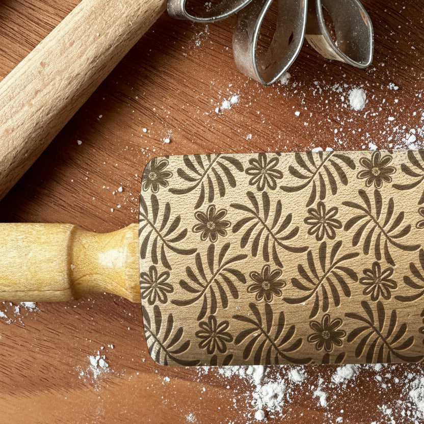 Decorative rolling pin with floral pattern on a wooden surface with flour, branded 'PickleandpeachStudio'.