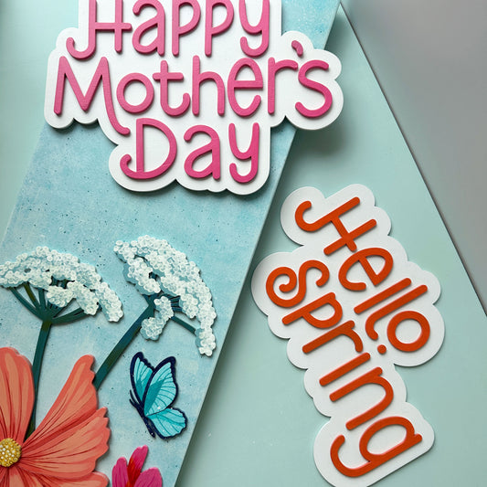 Sign with flowers and 'Happy Mother's Day' text, featuring an optional 'Hello Spring' saying on a light blue background.